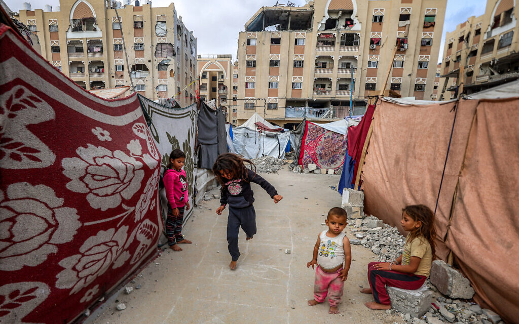 Children play outside tents sheltering people displaced by war at the Qatari-built and now-damaged Hamad City residential complex in northwestern Khan Younis, in the southern Gaza Strip, on October 6, 2025. (Omar AL-QATTAA / AFP)