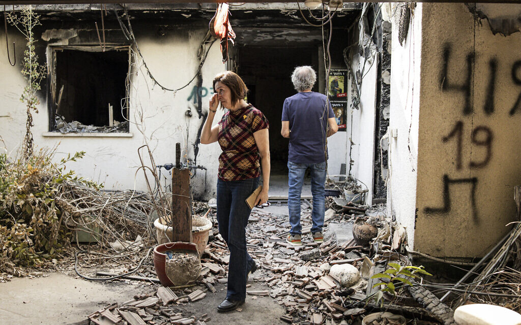 Adel Rubin (L), who lost both her parents during the 2023 October 7 attacks, reacts as she visits a house that was left heavily-damaged after the event in Kibbutz Nir Oz in southern Israel on October 6, 2025. (JOHN WESSELS / AFP)