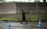 A mourner arrives for the funeral service of Adrian Daulby, one of two men killed in a terror attack on Heaton Park synagogue on October 2, at Agecroft Jewish Cemetery in Salford, in north-west England on October 6, 2025. (Paul ELLIS / AFP)