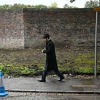 A mourner arrives for the funeral service of Adrian Daulby, one of two men killed in a terror attack on Heaton Park synagogue on October 2, at Agecroft Jewish Cemetery in Salford, in north-west England on October 6, 2025. (Paul ELLIS / AFP)