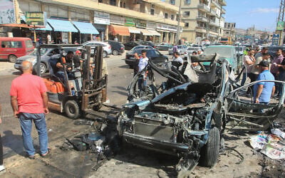 People gather around a destroyed car targeted in an Israeli drone attack in the southern Lebanese village of Zebdine, on October 6, 2025. (Mahmoud ZAYYAT / AFP) People gather around a destroyed car targeted in an Israeli drone attack in the southern Lebanese village of Zebdine, on October 6, 2025. (Mahmoud ZAYYAT / AFP)