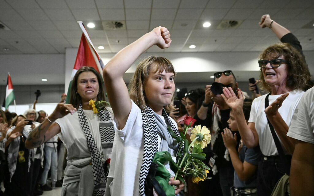 Swedish climate campaigner Greta Thunberg raises her fist, upon arrival in Greece on October 6, 2025, after being deported from Israel alongside other activists who were detained aboard vessels from the Gaza-bound Global Sumud Flotilla. (Aris MESSINIS / AFP)