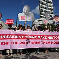People hold a banner and portraits of the hostages held in the Gaza Strip since October 7, 2023, during a rally in Tel Aviv marking the second anniversary of the assault by the Hamas terror group, on October 7, 2025. (Ahmad Gharabli/AFP)