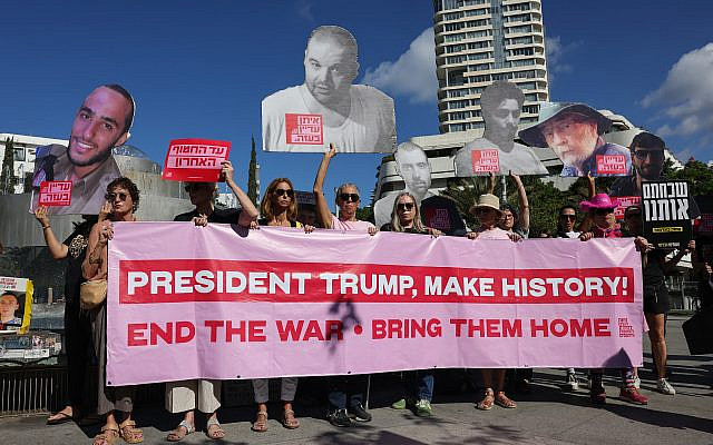 People hold a banner and portraits of the hostages held in the Gaza Strip since October 7, 2023, during a rally in Tel Aviv marking the second anniversary of the assault by the Hamas terror group, on October 7, 2025. (Ahmad Gharabli/AFP)
