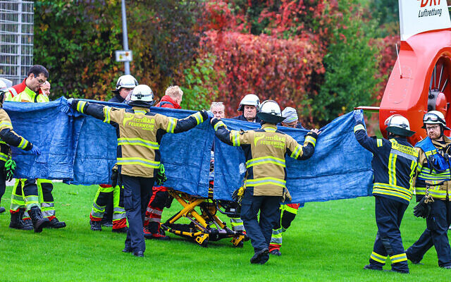 Firefighters and rescue workers transport Iris Stalzer, the newly elected mayor of Herdecke, on a stretcher before she is airlifted via helicopter after she was stabbed, in Herdecke, western Germany, on October 7, 2025. (Alex TALASH / AFP)