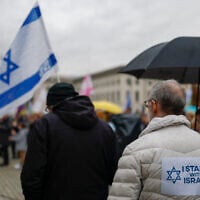 A man with a placard which reads "I stand with Israel" on his back is pictured during a vigil for the Israeli hostages, at Berlin's Bebelplatz on October 7, 2025. (Odd ANDERSEN / AFP)