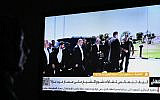 An Egyptian woman watches the news on a local channel in Cairo on October 8, 2025, showing images of top negotiator for the Palestinian Hamas movement Khalil al-Hayya (C) arriving in Sharm el-Sheikh for talks on ending the Gaza war.