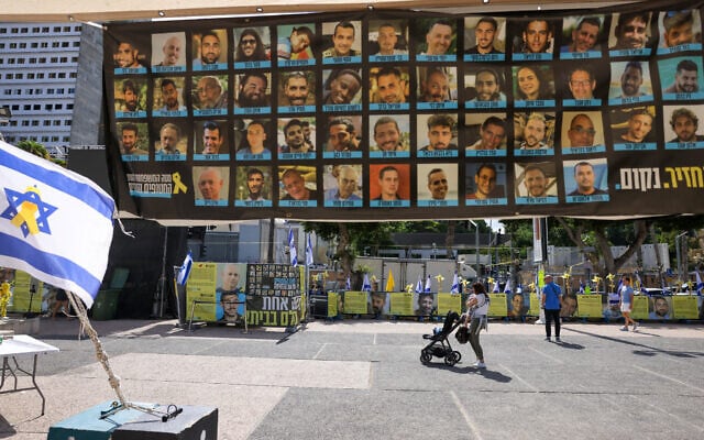 People walk past posters of hostages held by Palestinian terrorists in Gaza at Hostage Square in Tel Aviv on October 10, 2025 (AHMAD GHARABLI / AFP)