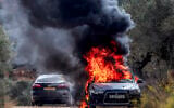 The vehicle of AFP photographer Jaafar Ashtiyeh is pictured ablaze after it was set on fire during an attack by Israeli settlers on the West Bank village of Beita, south of Nablus, during the annual olive harvest season, October 10, 2025. (Jaafar Ashtiyeh/AFP)