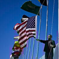 A municipal worker hoists a US flag next to those of other countries near Sharm el-Sheikh International Airport ahead of the arrival of world leaders for a 'peace summit,' in Sharm el-Sheikh on October 11, 2025. (Khaled DESOUKI / AFP)