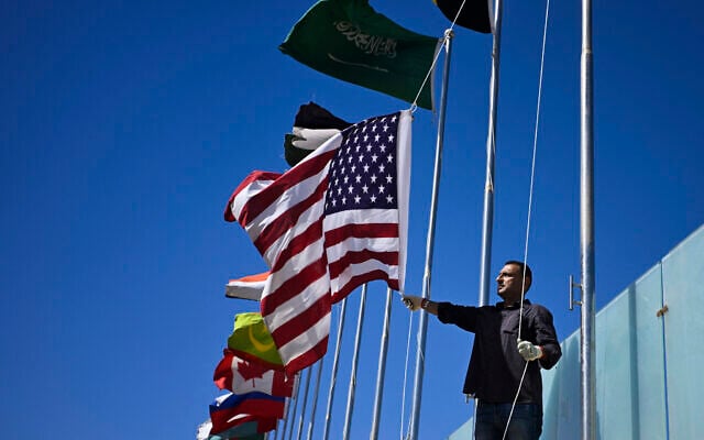 A municipal worker hoists a US flag next to those of other countries near Sharm el-Sheikh International Airport ahead of the arrival of world leaders for a "peace summit" in Sharm el-Sheikh on October 11, 2025. (Khaled DESOUKI / AFP)