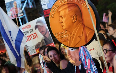 A demonstrator carries a mock Nobel Peace Prize depicting US President Donald Trump, at a rally at Tel Aviv's Hostages Square, October 11, 2025. (Jack GUEZ / AFP) A demonstrator carries a mock Nobel Peace Prize depicting US President Donald Trump, at a rally at Tel Aviv's Hostages Square, October 11, 2025. (Jack GUEZ / AFP)