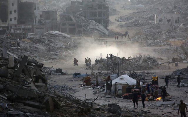 Palestinians make their way past destroyed buildings in Gaza City on October 12, 2025. (Bashar TALEB / AFP)