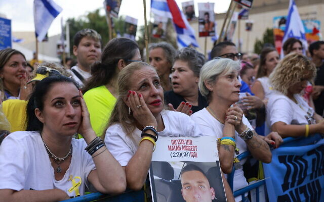 People holding portraits of Israeli hostages still held in Gaza wait for their release at Hostage Square in Tel Aviv early on October 13, 2025 (Menahem KAHANA / AFP)