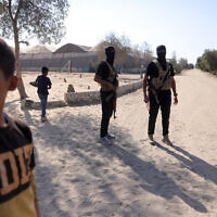 Members of the Hamas military wing stand guard before handing over the hostages on October 13, 2025. (Bashar TALEB / AFP)
