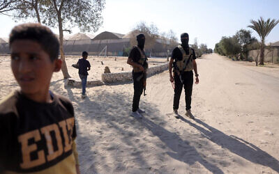 Members of the Hamas military wing stand guard before handing over the hostages on October 13, 2025. (Bashar TALEB / AFP)