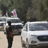 A Hamas gunman watches from the side of the road as vehicles of the International Committee of the Red Cross (ICRC) leave with the second batch of Israeli living hostages released by Hamas in Deir el-Balah in the central Gaza Strip, on October 13, 2025. (Bashar TALEB / AFP)