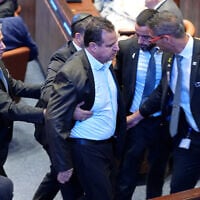 Knesset member Ayman Odeh (C) is escorted out after holding a sign reading "Recognize Palestine" during a speech by US President Donald Trump at the Knesset, in Jerusalem on October 13, 2025.  (Photo by Evan Vucci / POOL / AFP)