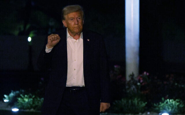 US President Donald Trump holds up his fist as he walks on the South Lawn after he landed at the White House on October 14, 2025 in Washington, DC. (Alex Wong/Getty Images/AFP)