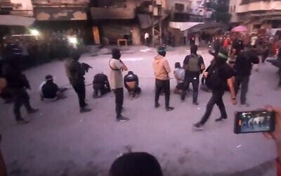 This image grab from a handout video released by the Hamas-run al-Aqsa TV's Telegram channel on October 13, 2025, shows Hamas gunmen executing blindfolded, bound and kneeling men as a crowd surrounds them in a street in Gaza City. (Al-Aqsa TV / AFP)