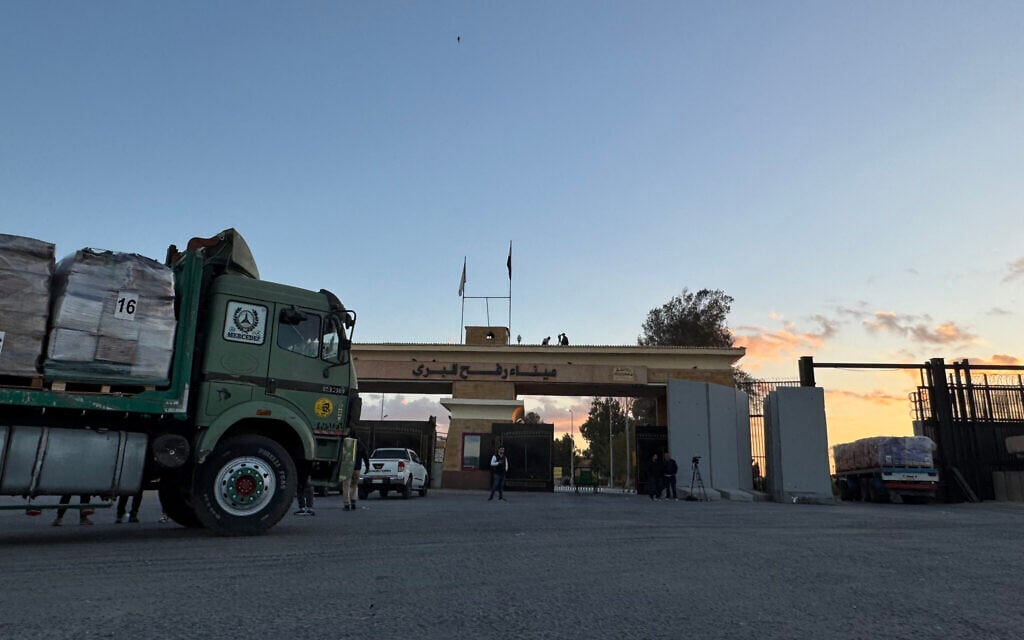 Trucks loaded with aid supplies move from the Egyptian side of Rafah, en route to the Kerem Shalom crossing, in the southern Gaza Strip, early on October 15, 2025. (AFP)