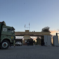 Trucks loaded with aid supplies move from the Egyptian side of Rafah, en route to the Kerem Shalom crossing, in the southern Gaza Strip, early on October 15, 2025. (AFP)