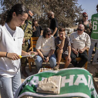 Members of the Kfar Aza kibbutz mourn in front of the grave of a victim as they hold a memorial service for those killed in Hamas's October 7, 2023 attack on Israel, in Kibbutz Kfar Aza on October 16, 2025. (Maya Levin / AFP)