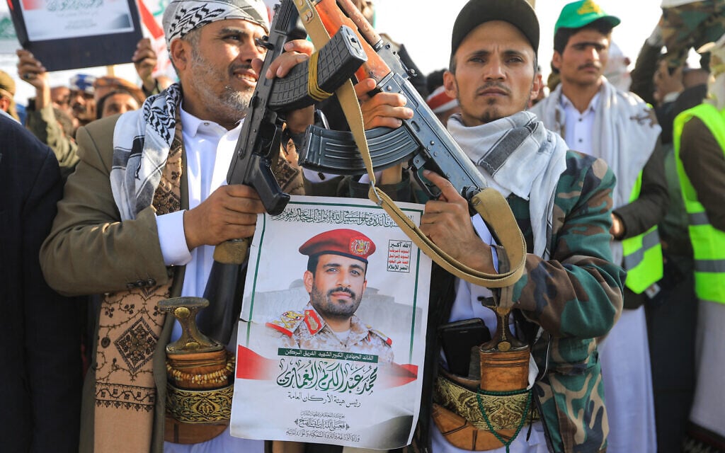 Supporters of Yemen's Houthis pose with a portrait of Major General Mohammed al-Ghamari, the Houthis' military chief, as they attend a rally condemning Israel a day after the Iran-backed group said that Ghamari had been killed in an Israeli attack earlier this year, in Sanaa on October 17, 2025 (Mohammed HUWAIS / AFP)