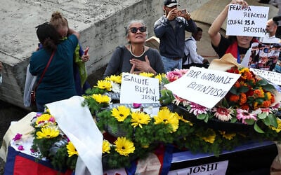 Mourners surround the coffin of slain hostage Bipin Joshi, before the repatriation of his body to Nepal, at Ben Gurion Airport, on October 19, 2025. (FADEL SENNA / AFP) Mourners surround the coffin of slain hostage Bipin Joshi, before the repatriation of his body to Nepal, at Ben Gurion Airport, on October 19, 2025. (FADEL SENNA / AFP)