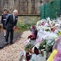 Britain's King Charles III looks at bouquets of flowers during a visit to Heaton Park Hebrew Congregation synagogue in Crumpsall, north Manchester, on October 20, 2025. (Chris Jackson / POOL / AFP)