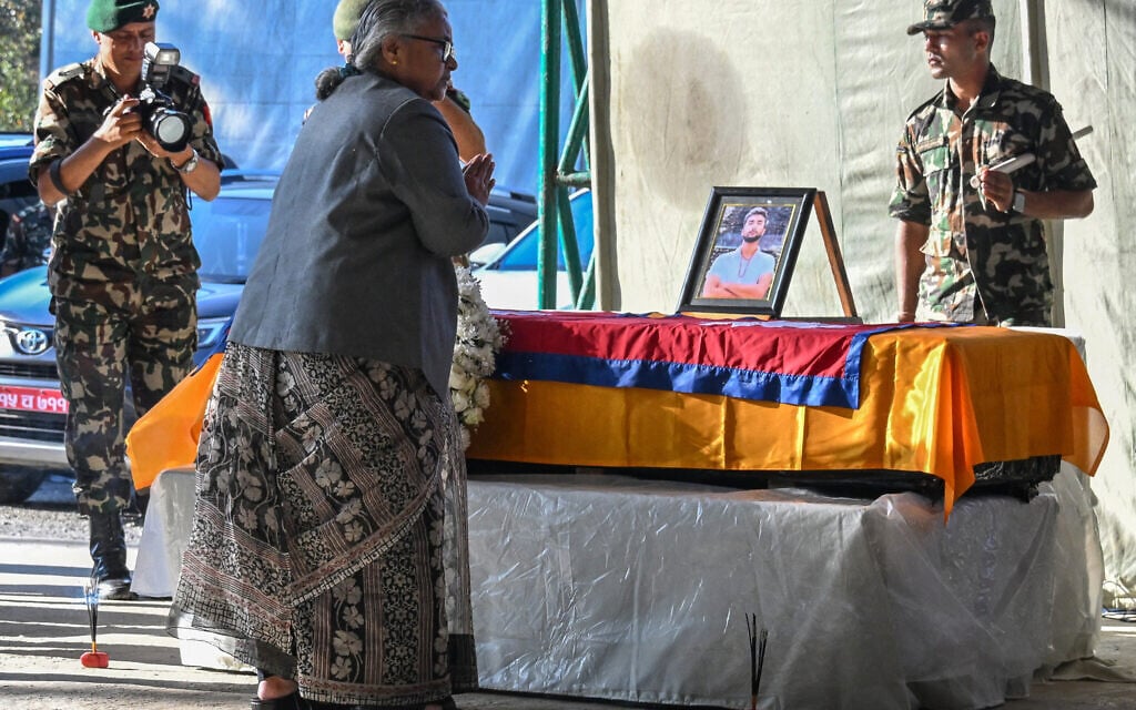 Nepal's interim Prime Minister Sushila Karki pays her last respects after draping the country's national flag over the coffin of Bipin Joshi, a Nepali student who was killed while held hostage in Gaza, at the Tribhuvan International Airport in Kathmandu on October 20, 2025, days after his body was returned from Hamas captivity (Prakash Mathema/AFP)