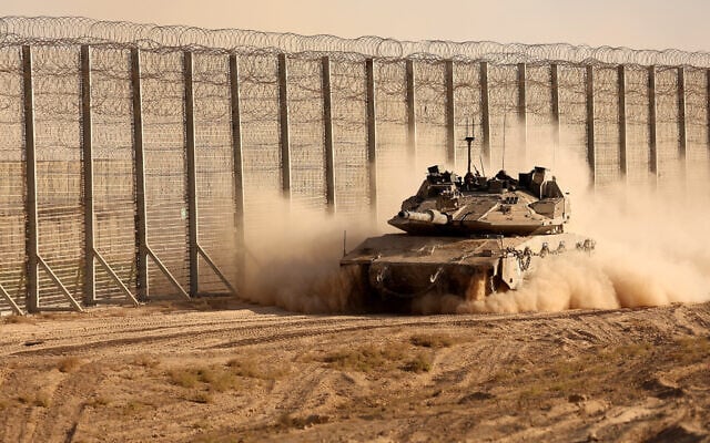 Israeli troops move along the border fence between Israel and the Gaza Strip on October 21, 2025. (Jack GUEZ / AFP)