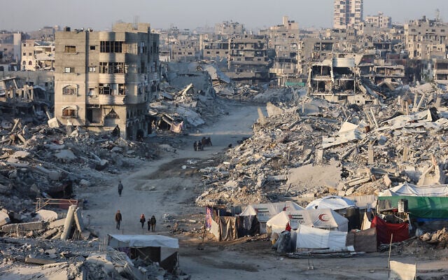 Palestinians walk past the rubble of destroyed buildings in the Sheikh Radwan neighborhood of Gaza City on October 22, 2025. (Omar AL-QATTAA / AFP) Palestinians walk past the rubble of destroyed buildings in the Sheikh Radwan neighborhood of Gaza City on October 22, 2025. (Omar AL-QATTAA / AFP)