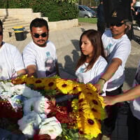 Loved ones of Thai national Sonthaya Oakkharasri stand next to his coffin during a farewell ceremony at Ben Gurion Airport in Tel Aviv, October 22, 2025. (Jack GUEZ / AFP)
