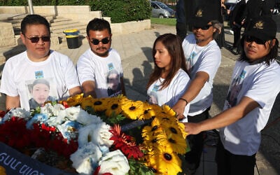Loved ones of Thai national Sonthaya Oakkharasri stand next to his coffin during a farewell ceremony at Ben Gurion Airport in Tel Aviv, October 22, 2025. (Jack GUEZ / AFP) Loved ones of Thai national Sonthaya Oakkharasri stand next to his coffin during a farewell ceremony at Ben Gurion Airport in Tel Aviv, October 22, 2025. (Jack GUEZ / AFP)