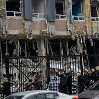 Residents walk near a damaged business center following a drone attack in Kyiv, on October 23, 2025, amid the Russian invasion of Ukraine. (Tetiana DZHAFAROVA / AFP)