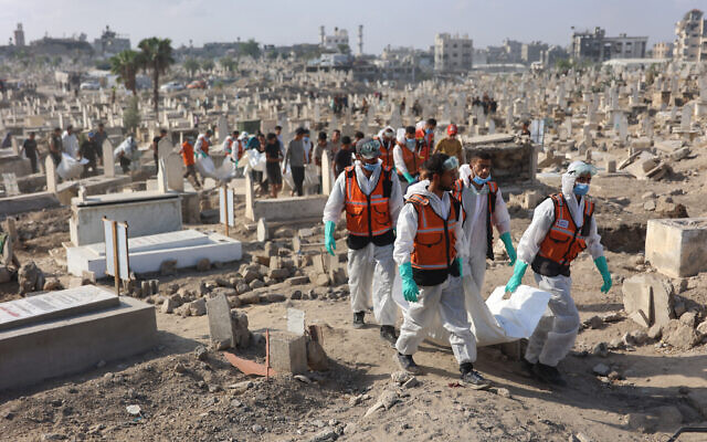Civil Defense members carry body bags containing the remains of members of the Shahebar family who were buried in temporary graves, as they are brought for burial to the Sheikh Shaaban Cemetery, in Gaza City on October 24, 2025. (Photo by Omar AL-QATTAA / AFP) Civil Defense members carry body bags containing the remains of members of the Shahebar family who were buried in temporary graves, as they are brought for burial to the Sheikh Shaaban Cemetery, in Gaza City on October 24, 2025. (Photo by Omar AL-QATTAA / AFP)