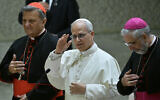 Pope Leo XIV delivers his blessing, next to Cardinal Mario Grech (L) and Bishop Luis Marin de San Martin (R) after participating in the Synod Teams and Participatory Bodies in Paul VI Hall at the Vatican on October 24, 2025. (Filippo MONTEFORTE / AFP)