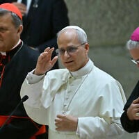 Pope Leo XIV delivers his blessing, next to Cardinal Mario Grech (L) and Bishop Luis Marin de San Martin (R) after participating in the Synod Teams and Participatory Bodies in Paul VI Hall at the Vatican on October 24, 2025. (Filippo MONTEFORTE / AFP)