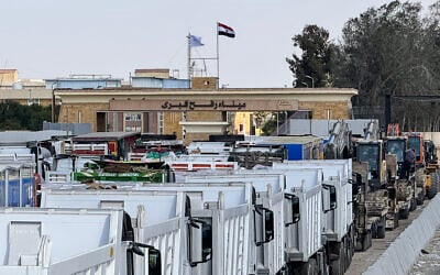 Egyptian trucks and heavy machinery line up on the Egyptian side of the Rafah border crossing with the Gaza Strip on October 26, 2025. (AFP)