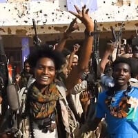 RSF fighters holding weapons and celebrating in the streets of El-Fasher in Sudan's Darfur region, in a screengrab of a video published on Telegram, on October 26, 2025. (Rapid Support Forces / AFP)