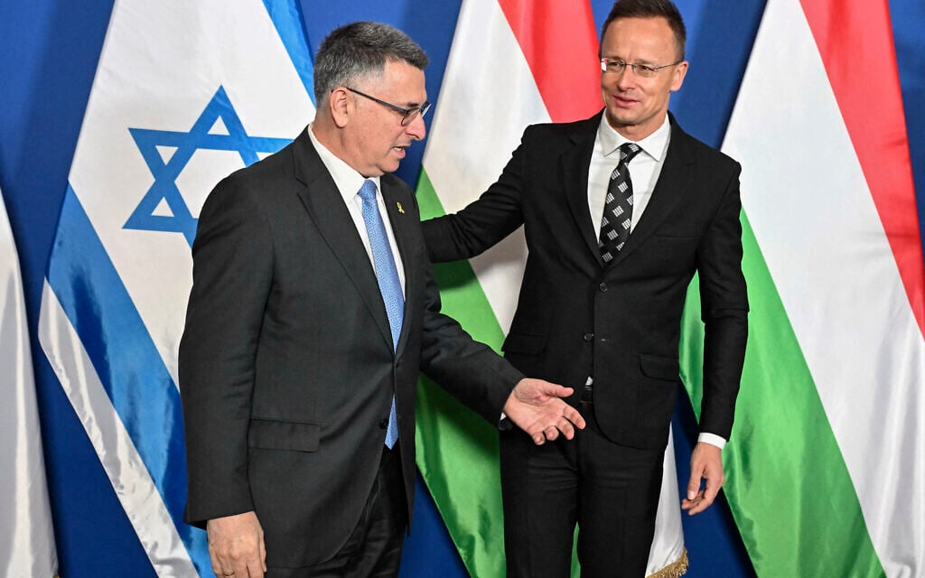 Foreign Minister Gideon Sa'ar (L) is welcomed by his Hungarian counterpart Peter Szijjarto prior to their official talks at Puskas Arena in Budapest, on October 27, 2025. (Attila KISBENEDEK / AFP)
