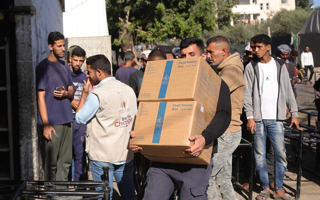 A Palestinian man collects food ration boxes provided by the World Food Programme (WFP), at a distribution centre in the village of Al-Zawayda, in the centre of the Gaza Strip on October 27, 2025. (Bashar Taleb/AFP)