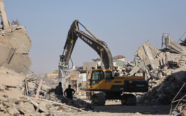 An excavator operates in the al-Tuffah neighborhood of Gaza City on October 27, 2025. (Omar AL-QATTAA / AFP)
