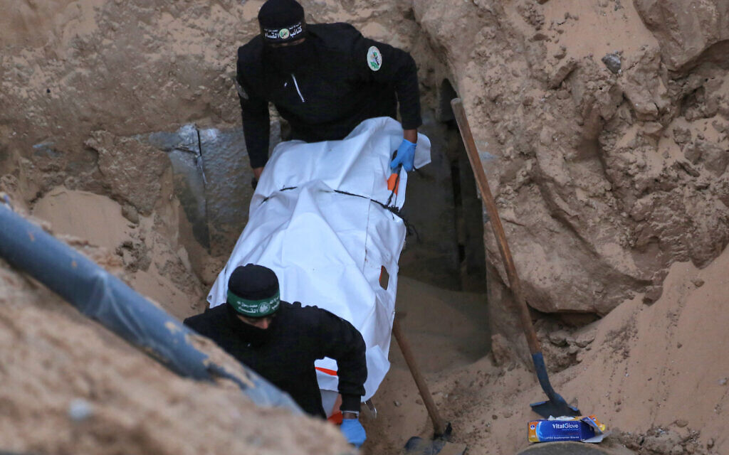 Hamas members carry a body retrieved from a tunnel in an area north of Khan Yunis in the southern Gaza Strip on October 28, 2025. (Photo by Bashar TALEB / AFP)