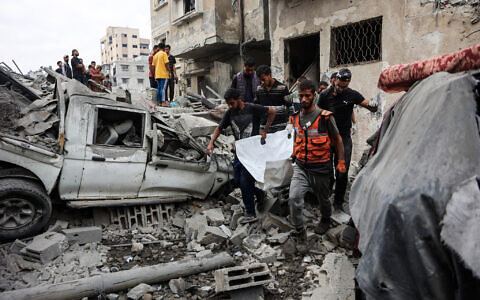 Palestinians recover a body from the rubble of a house destroyed in an overnight Israeli strike in Gaza City on October 29, 2025. (Omar AL-QATTAA / AFP)
