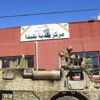 A Lebanese soldier sits on top of a military vehicle outside the municipality building of the southern Lebanese border village of Blida in the aftermath of an Israeli army raid on the village, October 30, 2025. (Mahmoud ZAYYAT / AFP)