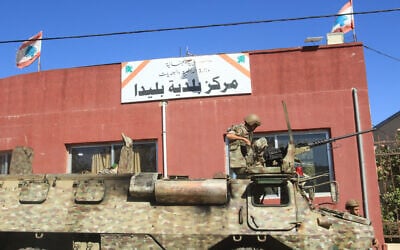 A Lebanese soldier sits on top of a military vehicle outside the municipality building of the southern Lebanese border village of Blida in the aftermath of an Israeli army raid on the village, October 30, 2025. (Mahmoud ZAYYAT / AFP)