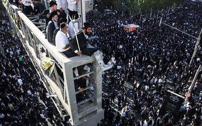 Ultra-Orthodox men sit on a bridge overlooking the crowd during a protest by ultra-Orthodox Jews against conscription into Israel's military in Jerusalem on October 30, 2025. (AHMAD GHARABLI / AFP)