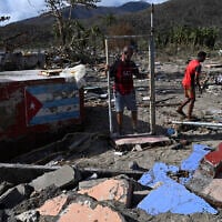 A man holds the gate of a damaged house after the passage of Hurricane Melissa in Boca de Dos Rios village, Santiago de Cuba province, Cuba on October 30, 2025. (Yamil Lage/AFP)